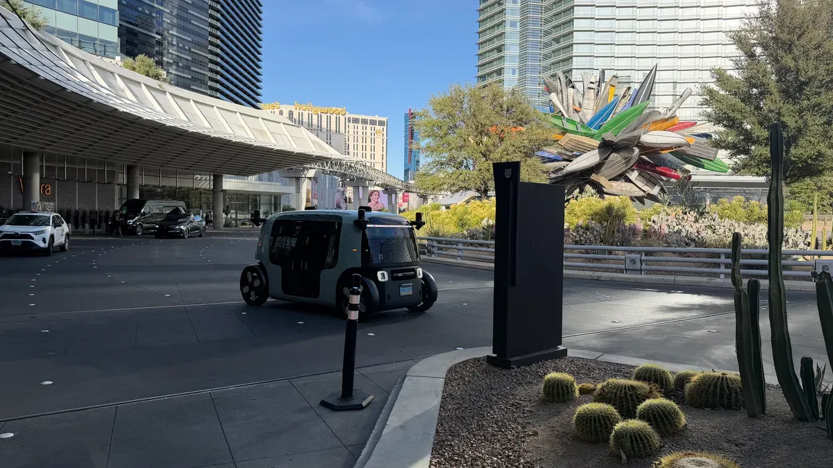 Amazon Zoox robotaxi driving past modern buildings in Las Vegas