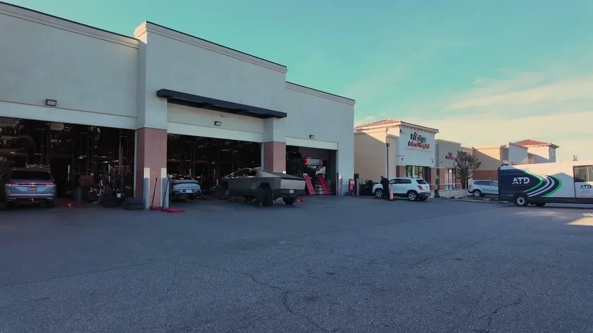 Wide exterior view of America's Tire service center with Cybertruck and ATD truck.