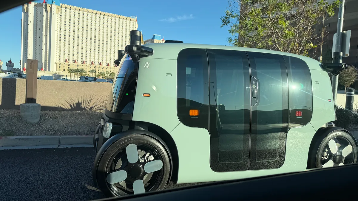 Zoox autonomous shuttle driving past a hotel in Las Vegas