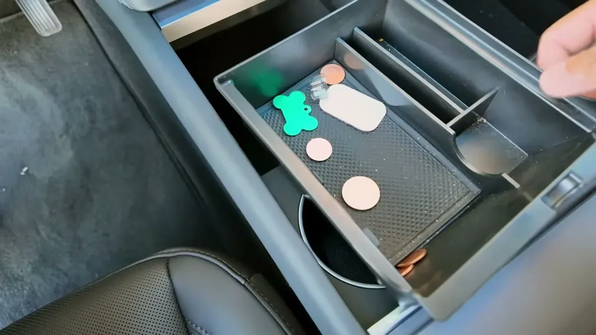 Black center console organizer tray sitting incorrectly in the Model Y Juniper center console, unable to close