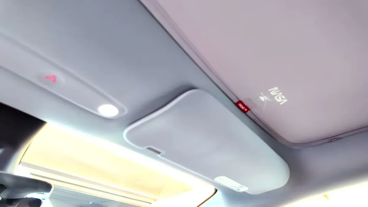 Interior view of the Model Y Juniper roof showing the HaloBlk roof shade partially installed across the front glass