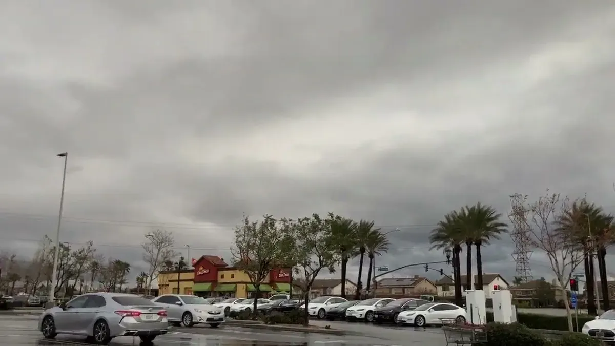 Cloudy SoCal parking lot, palm trees and a restaurant in the background