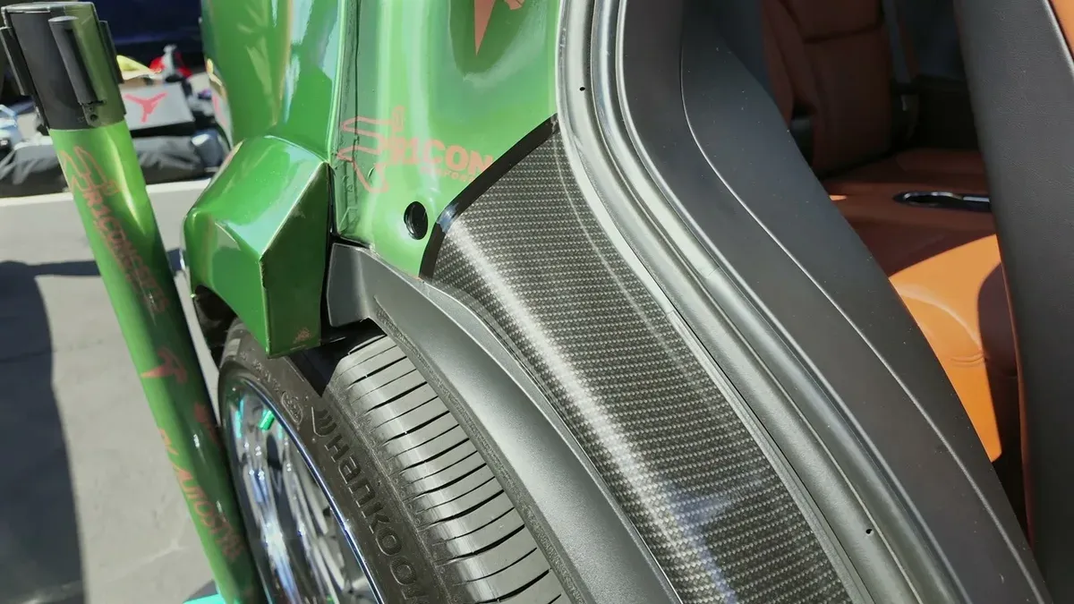 Carbon fiber fender liner and custom wheel well detail on George's Model X, EV Auto Styles branding visible