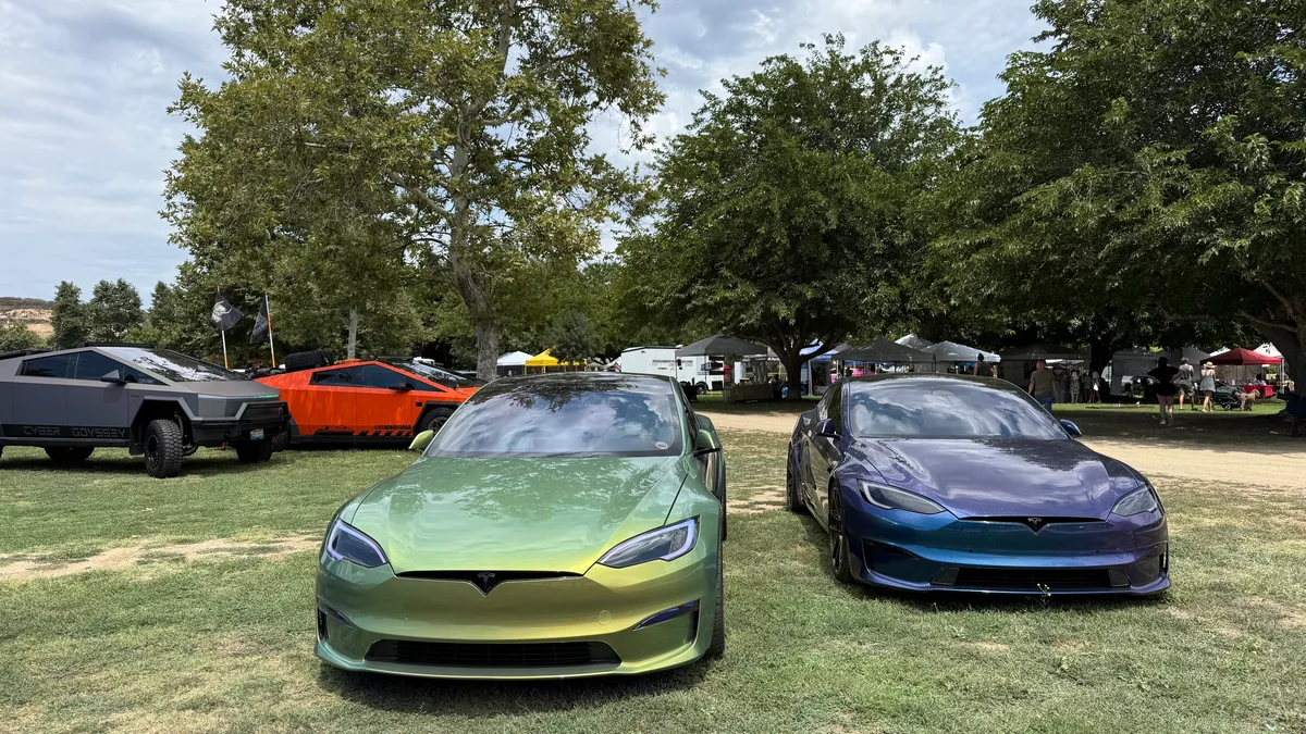 Two custom-wrapped Tesla Model S cars in chameleon green-gold and blue-purple finish at the event