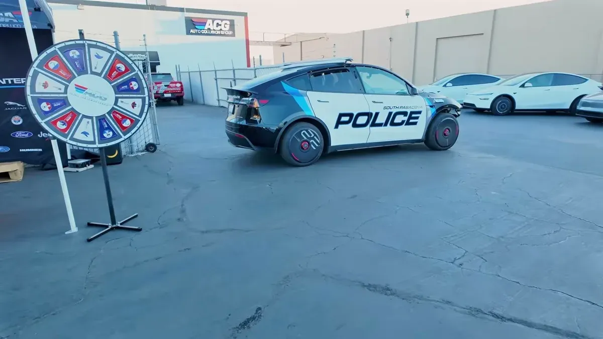 Customized black and white Tesla Model Y with POLICE decals and unique wheel covers.