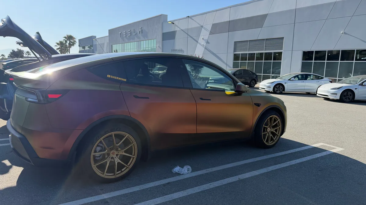 Custom-wrapped Tesla Model Y Juniper parked outside a Tesla service center