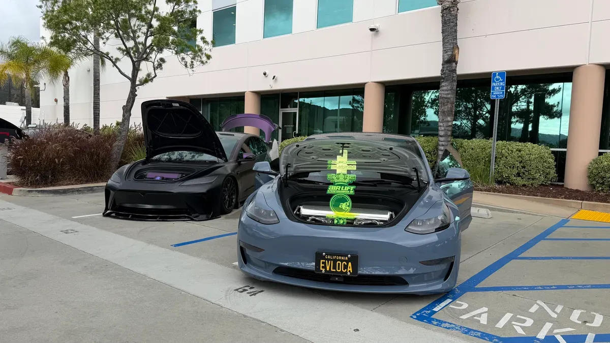 Two custom Tesla Model 3s with frunks open and EVLOCA license plate.