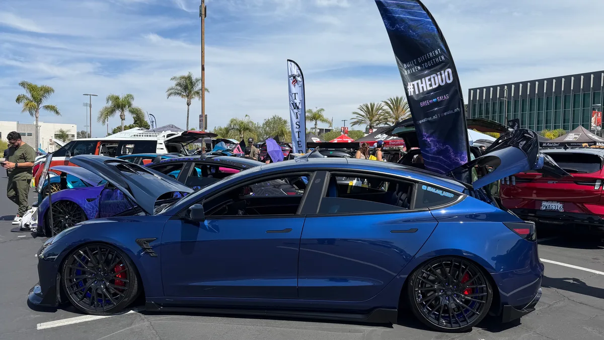 Customized blue Tesla Model 3 with widebody kit and red calipers at EV Fest 2026.