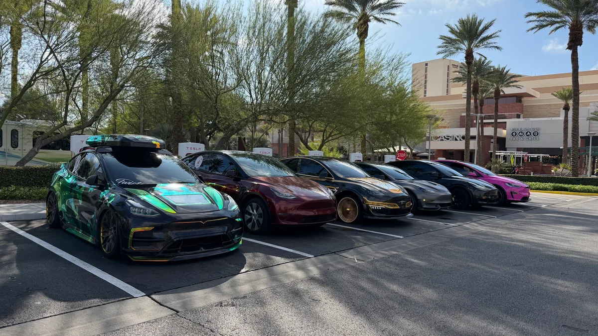 Line of modified Tesla vehicles at a Supercharger station with palm trees during the Zero Emissions Run Las Vegas