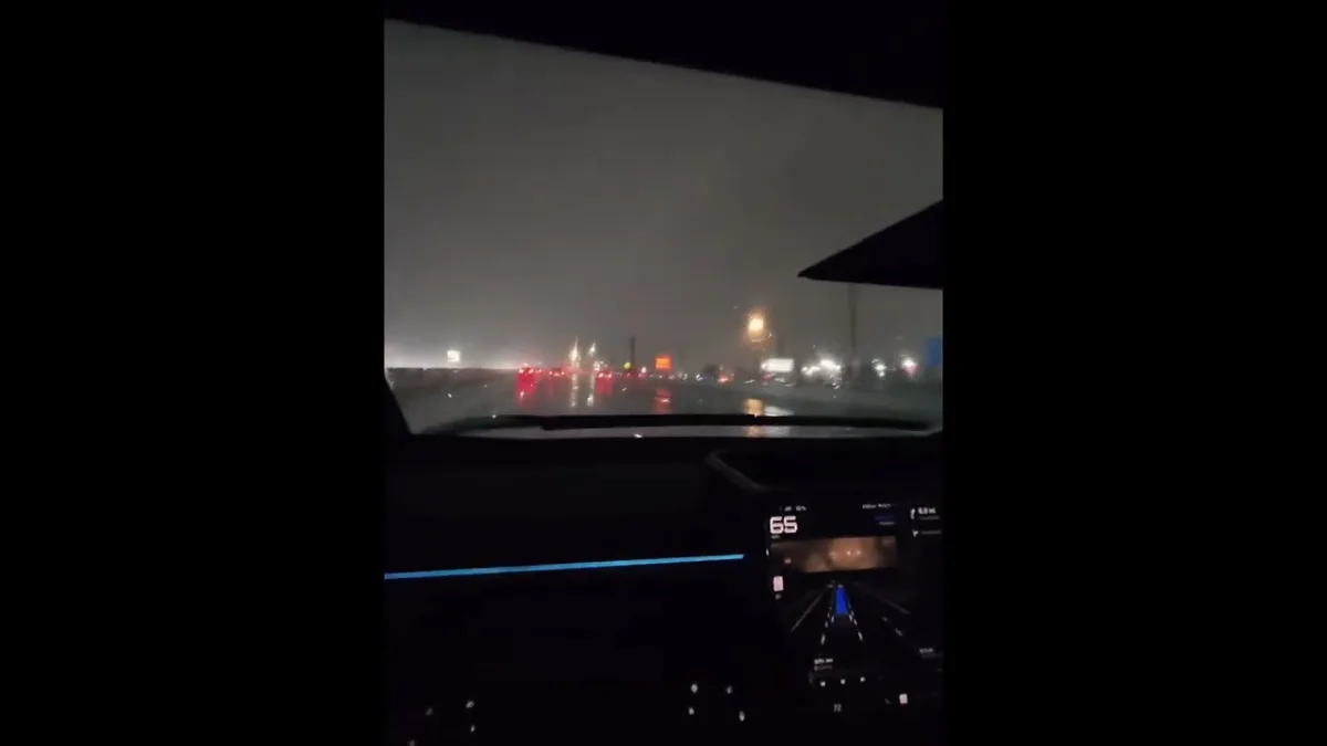 FSD navigation display visible on the Cybertruck touchscreen with lane detection active while driving on a wet highway at night