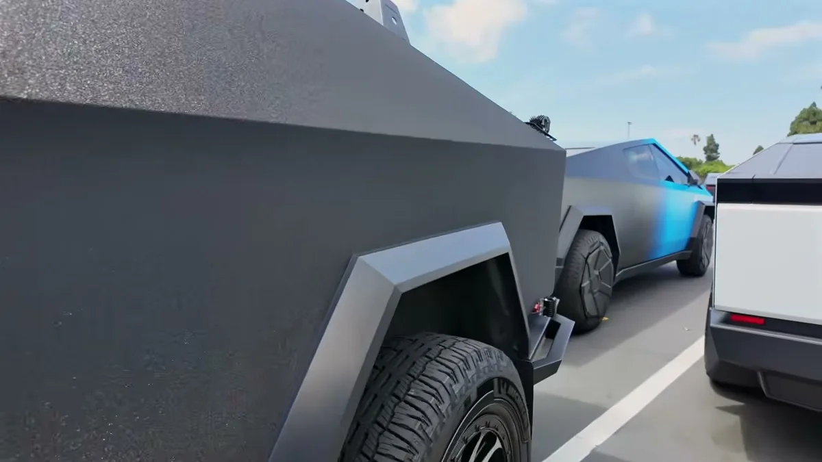 Cybertruck rear wheel at EV Fest with blue gradient Cybertruck in background