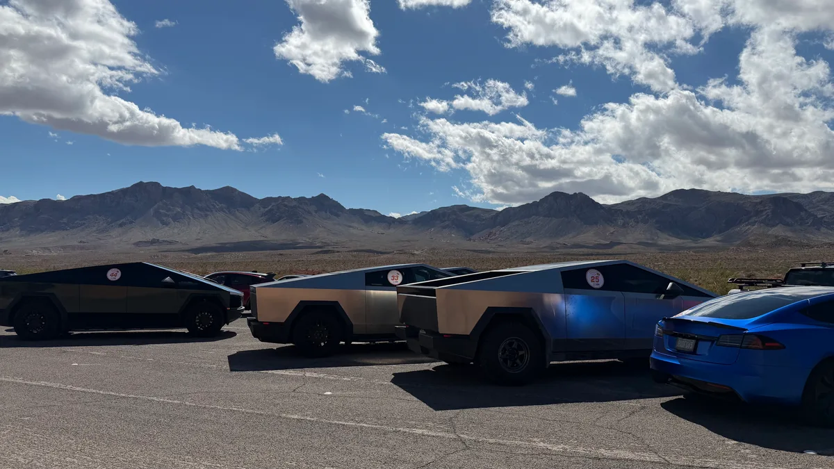 Cybertruck convoy parked in the Valley of Fire State Park desert with red rock mountains in background