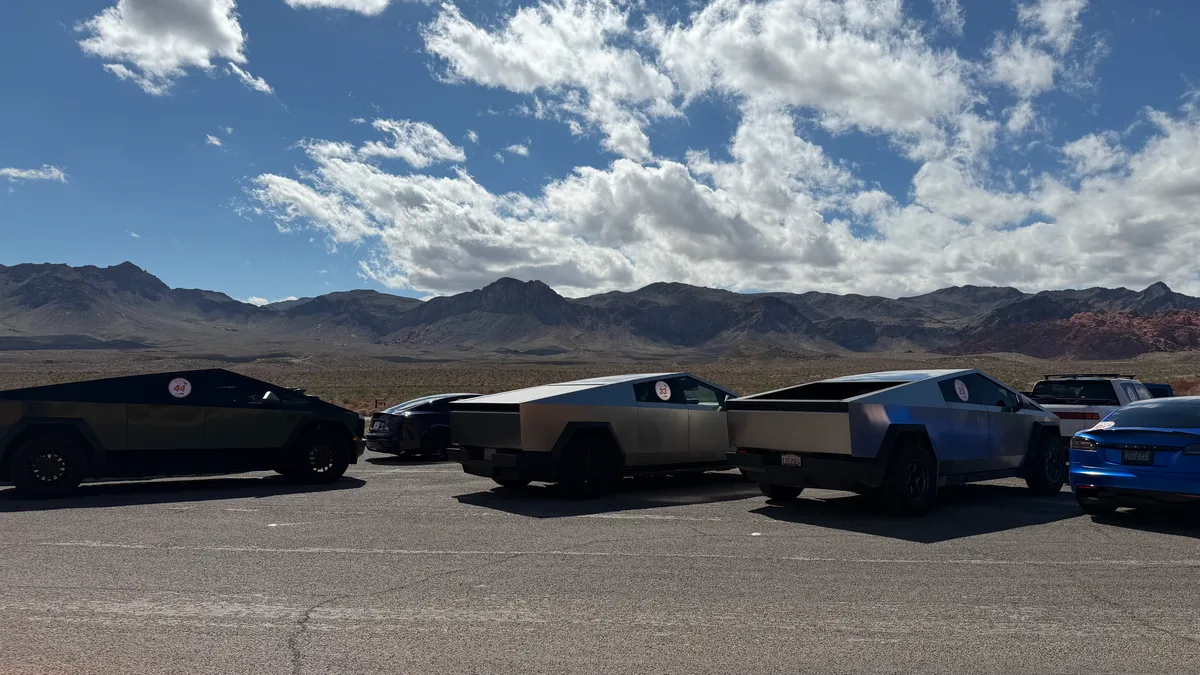Multiple Cybertrucks and a Model X parked in the Valley of Fire desert with mountain backdrop