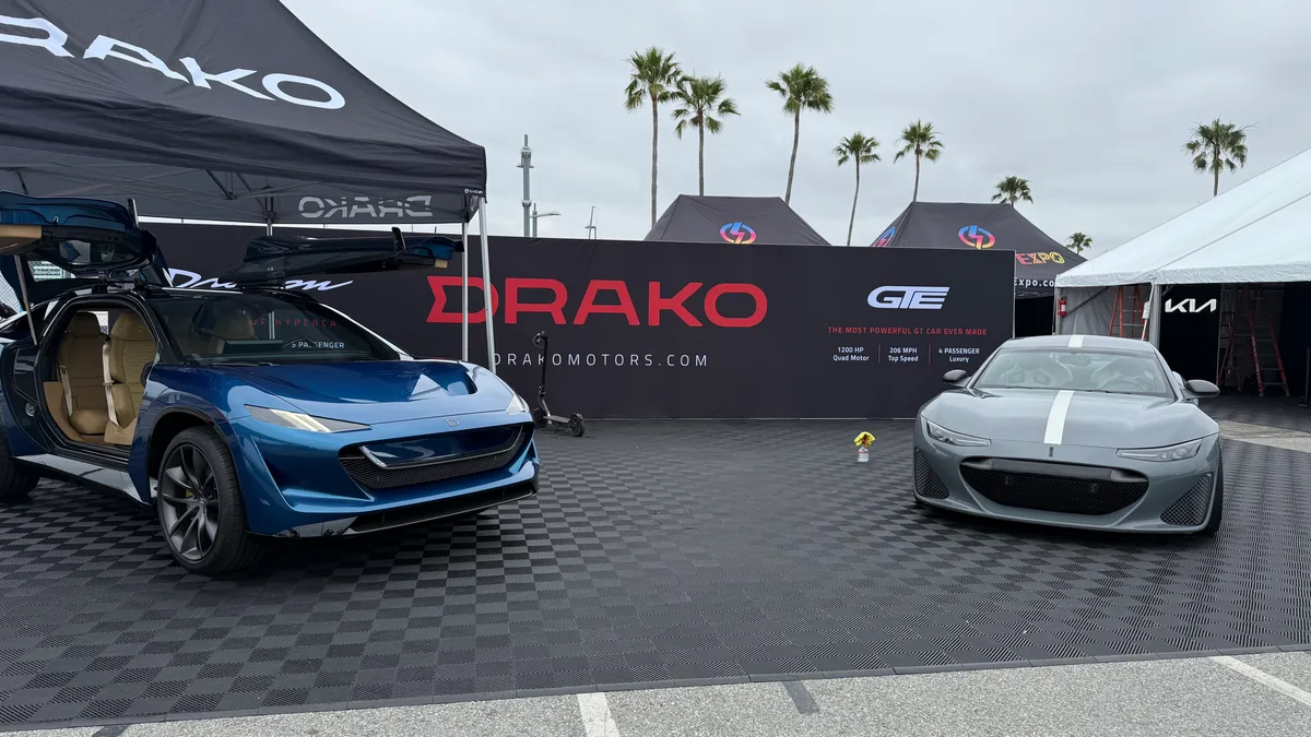 Blue Drako Dragon and grey Drako GTE displayed side by side under the Drako banner at Electrify Expo