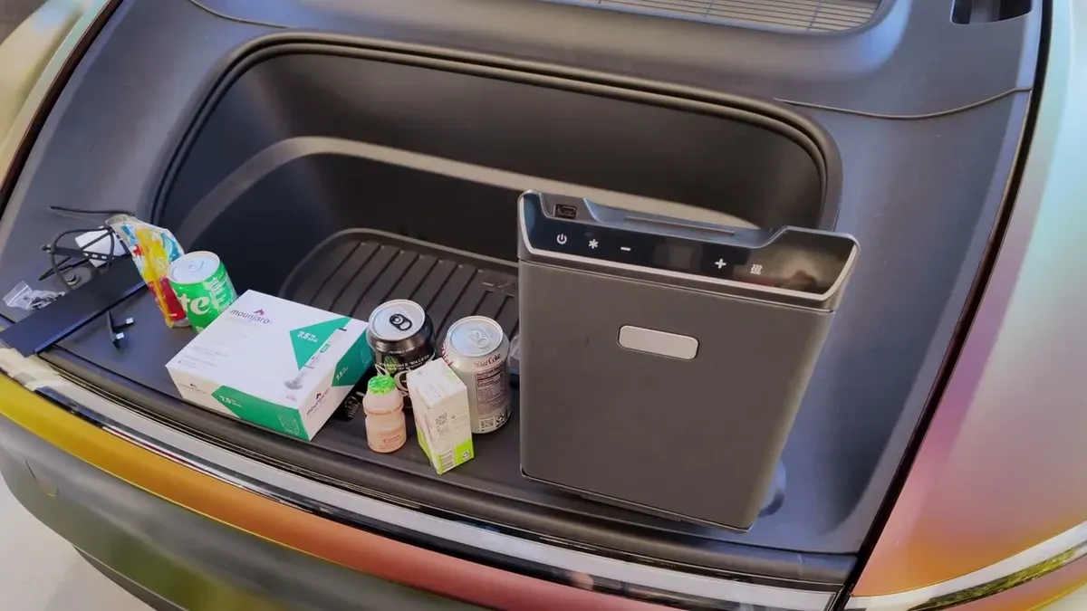 Overhead view of the fridge in the frunk packed with cans, bottles, and small boxes showing total capacity