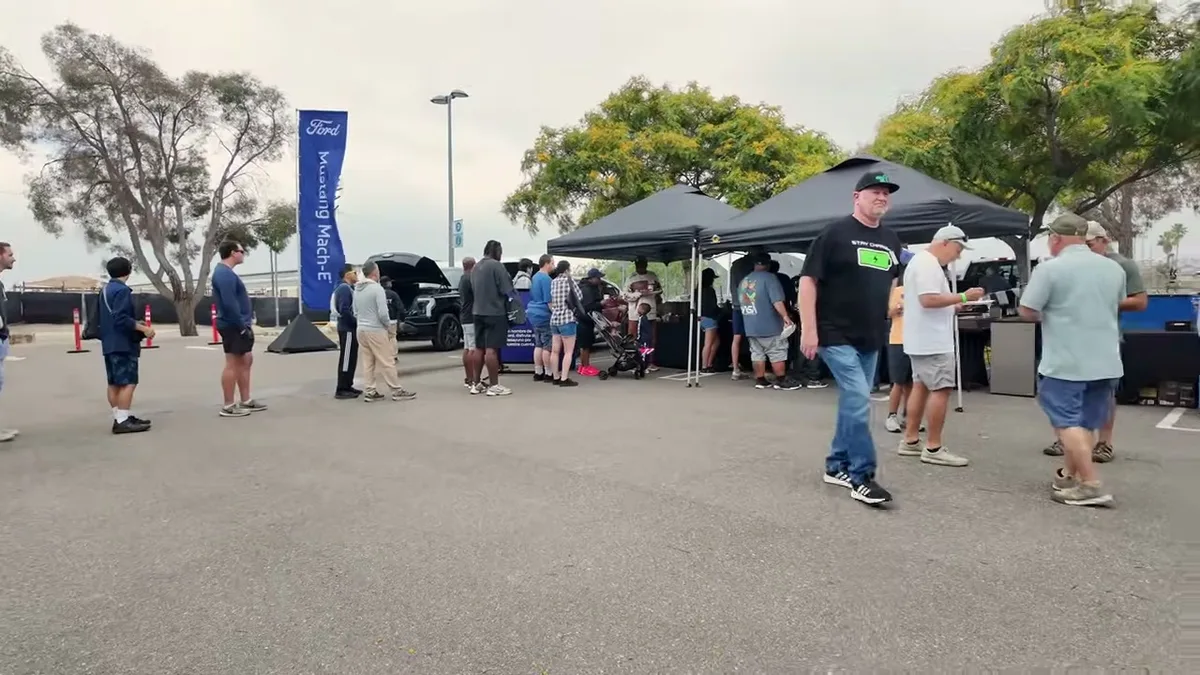 People walking around Ford Mach-E display at Electrify Expo event