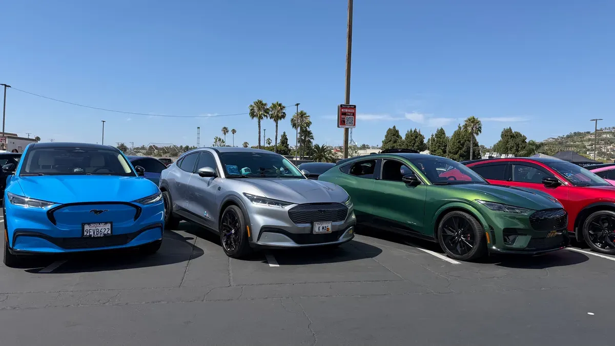 Lineup of Ford Mustang Mach-E electric SUVs in blue, silver, and green at EV Fest 2026 in Long Beach.