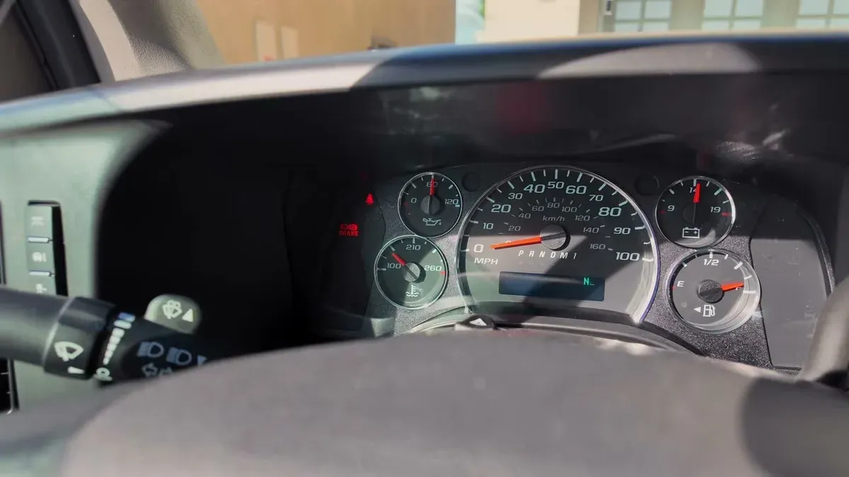 Gas car dashboard showing speedometer, tachometer, fuel gauge, oil temperature, and gear selector in neutral