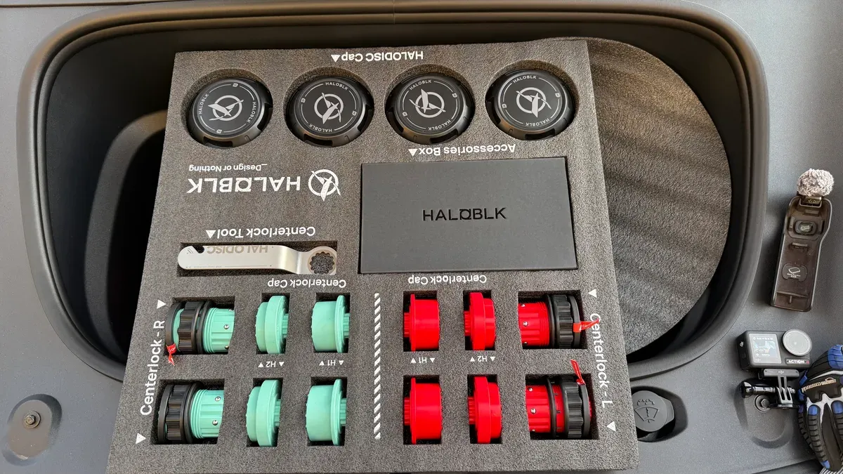 HALOBLK centerlock wheel cap kit with red, mint green, and black caps, tool, and accessories box in a car frunk.