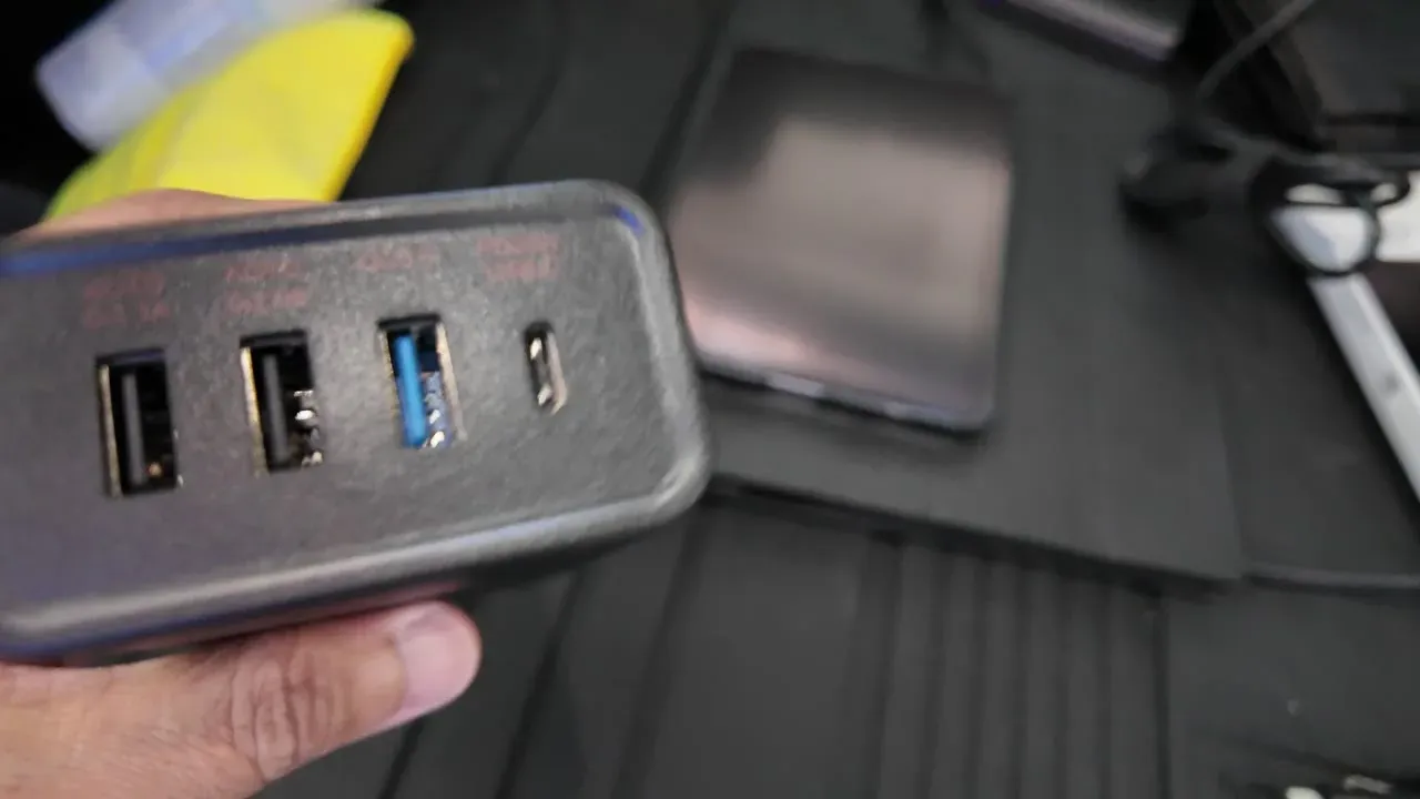 Close-up of the Hansshow inverter's port end, showing three USB-A ports including one blue QC 3.0 and a single USB-C PD port.