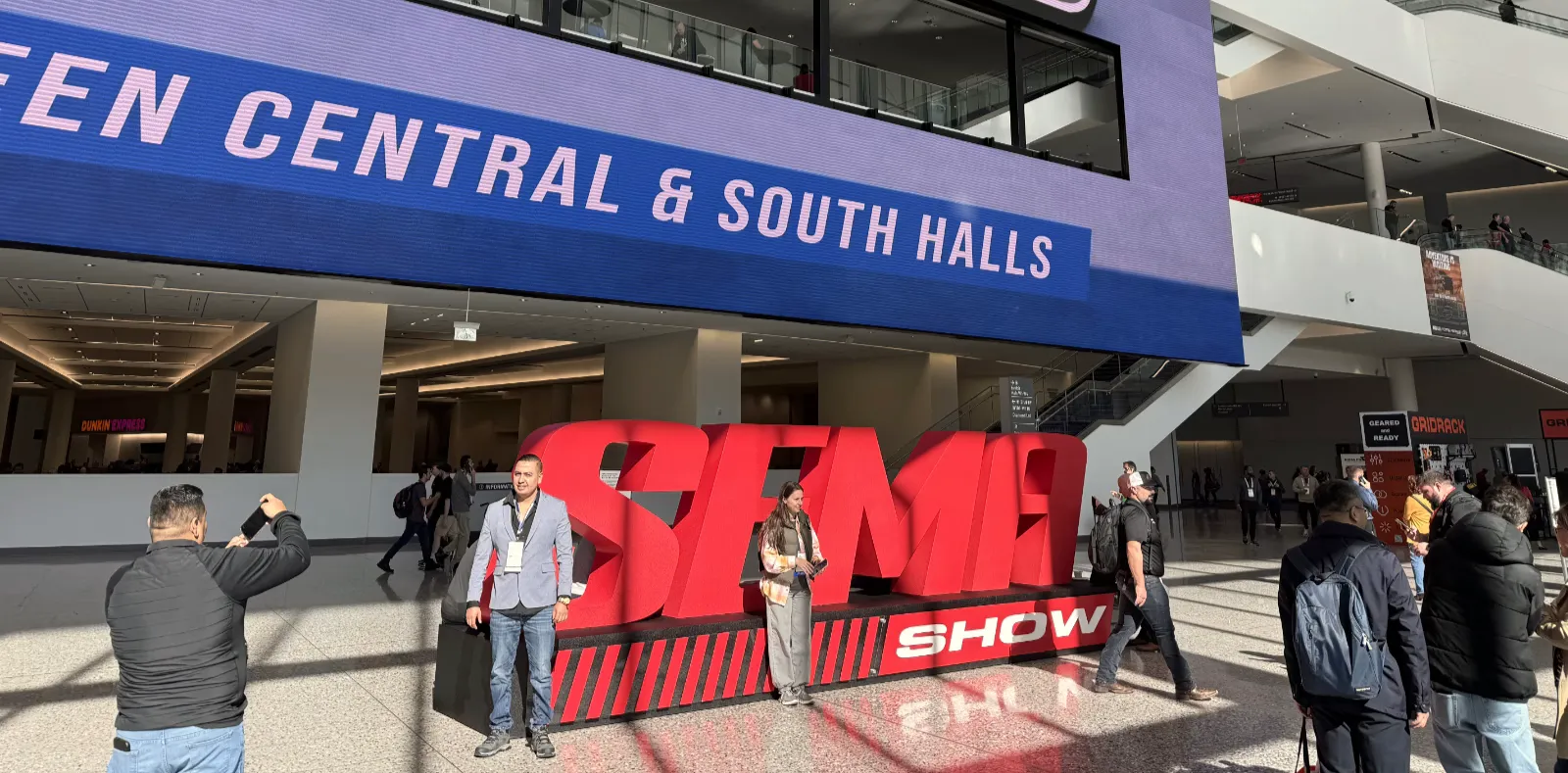 People standing in front of SEMA sign