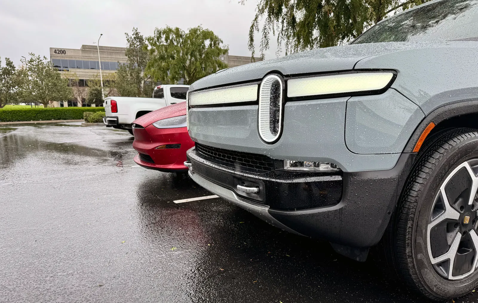Front view of R1T and Model X in a rainy day