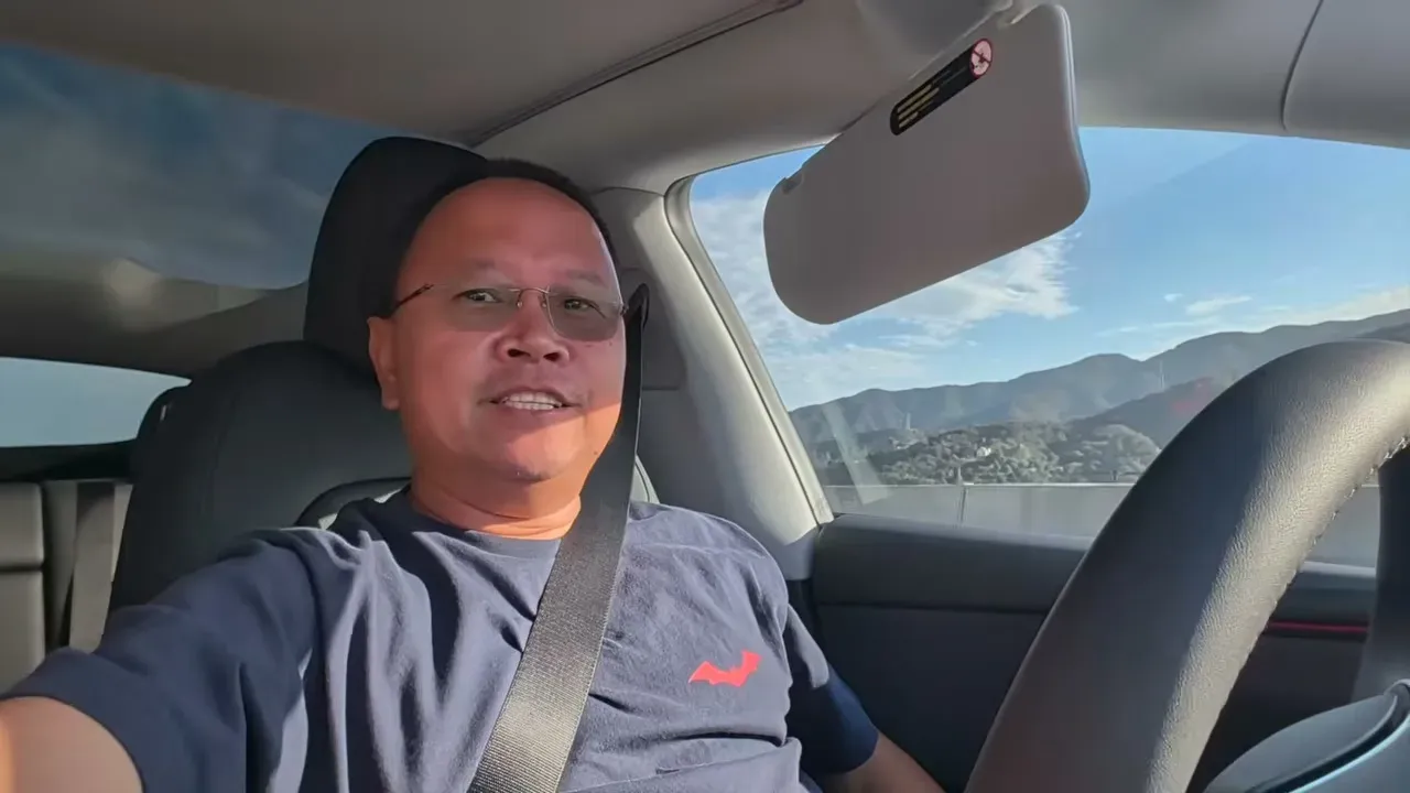 Sherwin behind the wheel of the Tesla Model Y Juniper driving north on FSD with the Grapevine mountains in the passenger window