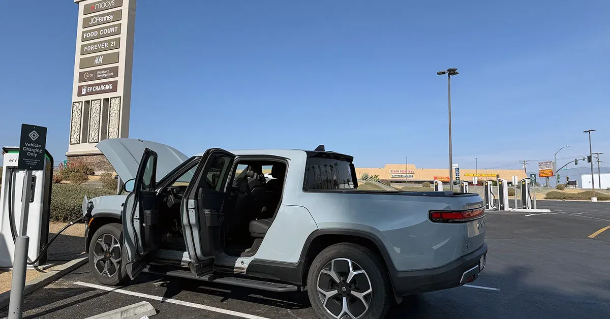 Electric truck charging at station.