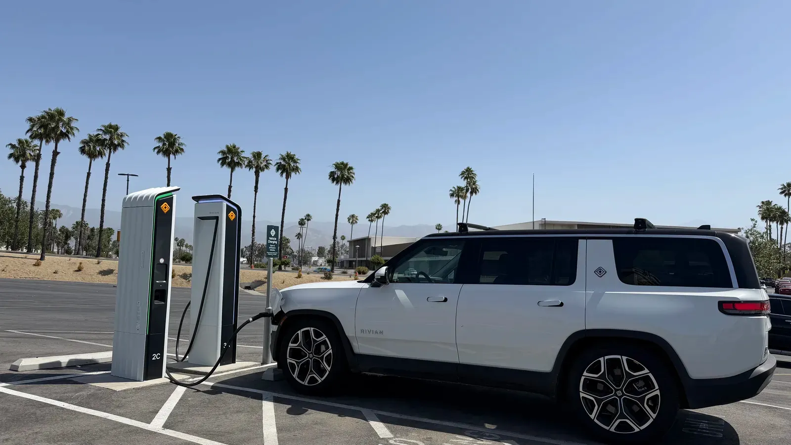 Sherwin holding CCS-to-NACS adapter at San Bernardino Rivian Adventure Network charger