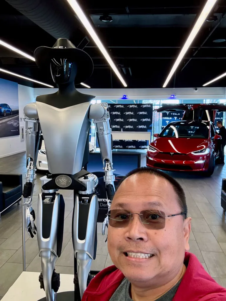 Guy standing in front of Tesla Optimus