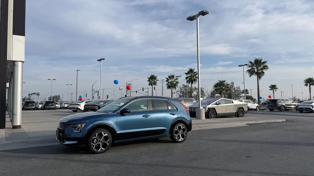 Kia Niro at dealership with Cybertruck in the back