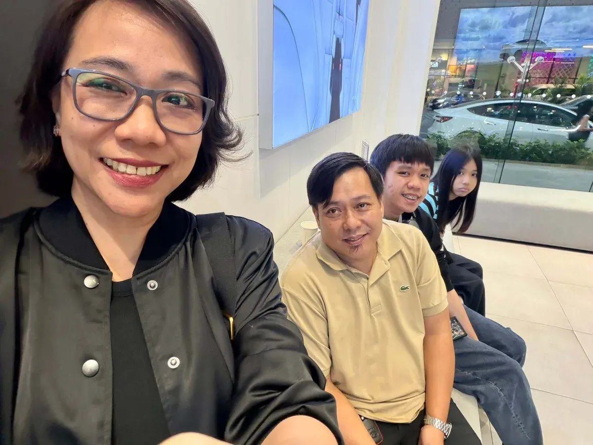 Joy taking a selfie with her family while waiting inside the Tesla showroom in the Philippines