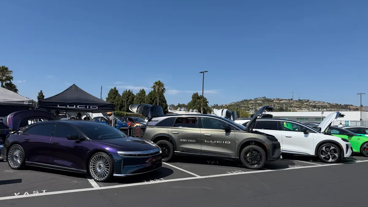 Purple Lucid Air sedan and khaki Lucid Gravity SUV with mobile service branding at EV Fest 2026.