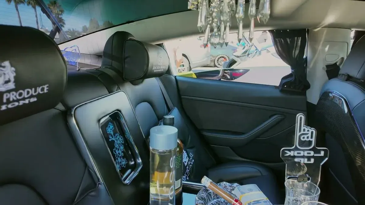 Custom rear interior of Marvin's 2022 Model 3 showing crystal chandelier, Junction Produce headrests, and crystal glassware at EV Fest 2026