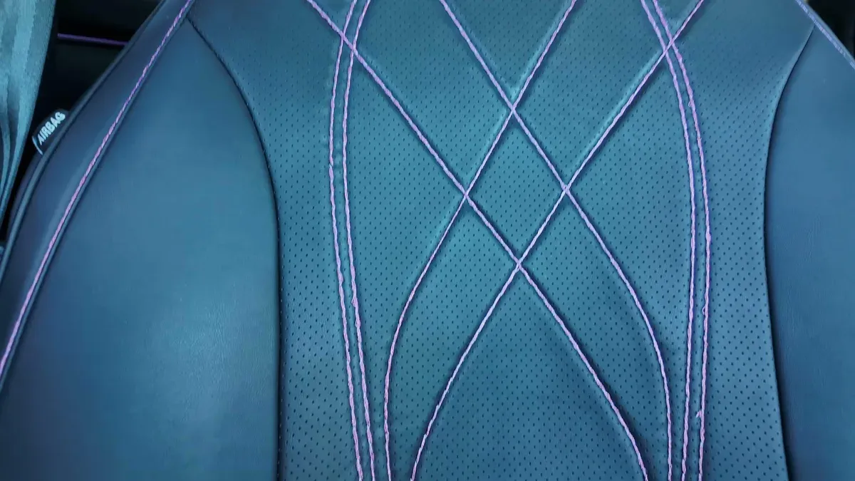 Close-up of hand-stitched perforated black seat with purple diamond pattern stitching in Keisha's Mustang Mach-E