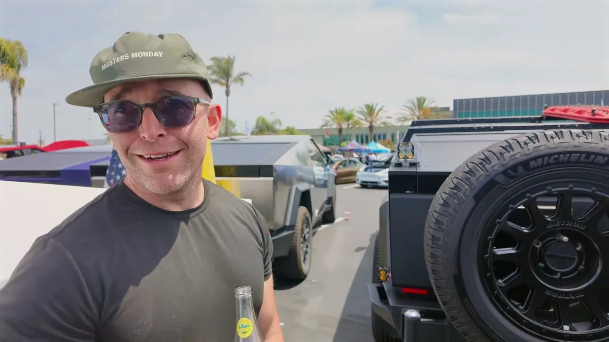 Anwar smiling at EV Fest 2026 with modified Cybertrucks in background