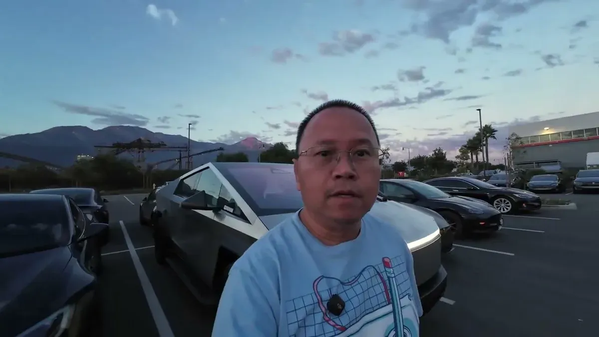 Man in parking lot at sunset with Cybertruck visible behind him, mountains in the distance