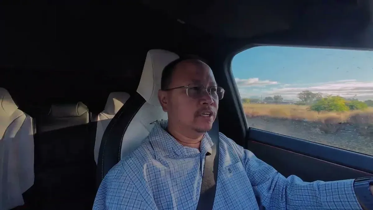 Man driving with open desert highway stretching ahead and mountains on the horizon