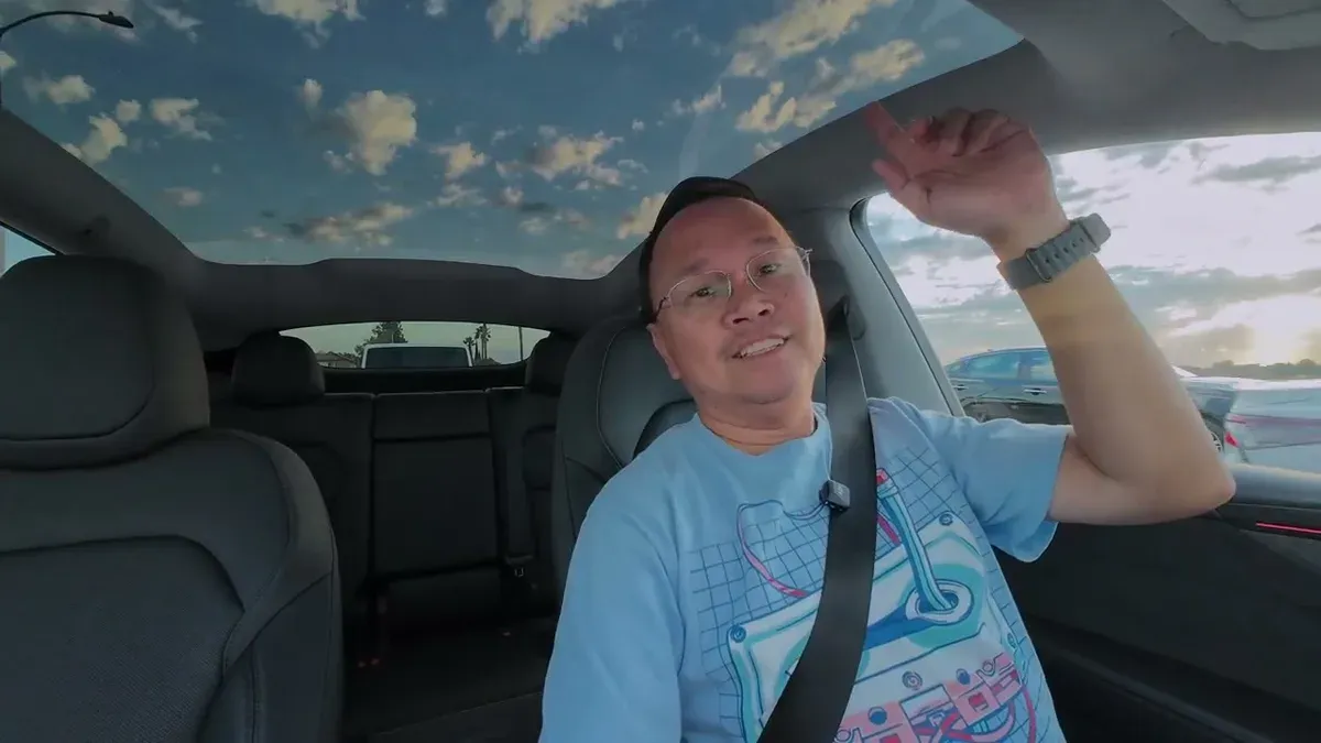 Man driving Launch Series, gesturing while talking about missing his roof shade