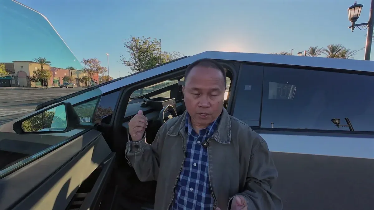 Man gesturing next to open Cybertruck door, explaining the alignment issue