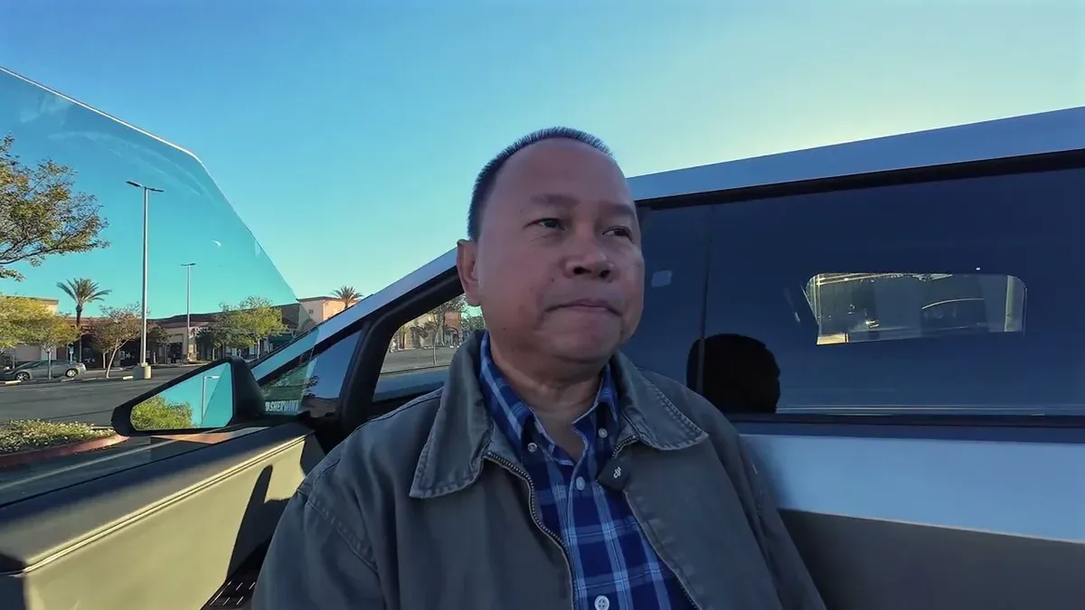 Man back in Cybertruck driver's seat after service pickup, reviewing the results