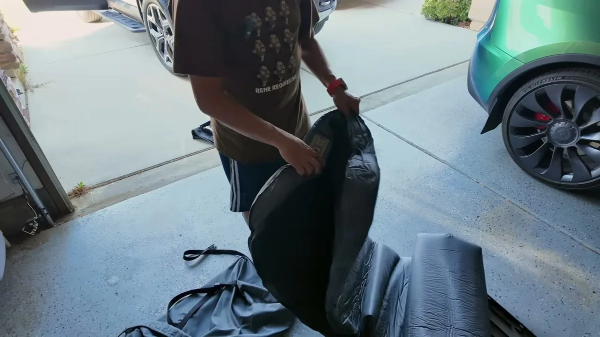 Sherwin holding the built-in black air pump that comes with the EVBase R1S mattress