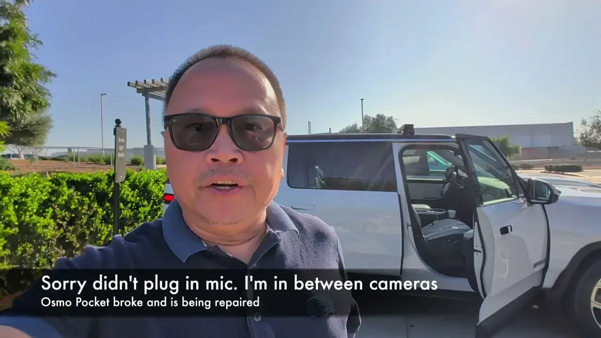 Sherwin outside white Rivian R1S Gen 2 at the Rivian Irvine service center