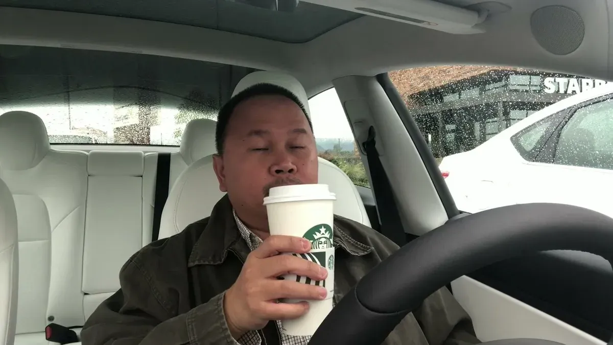 Sherwin drinking his Starbucks birthday drink in the Tesla
