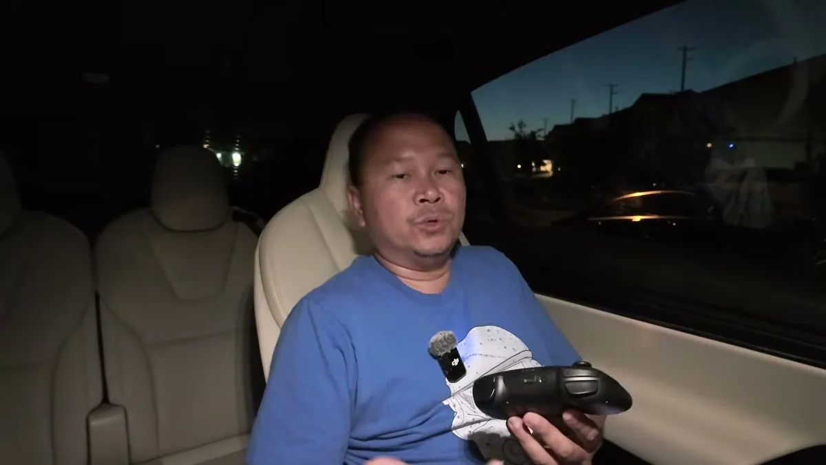 Sherwin at night in the Model X holding the Jowua controller