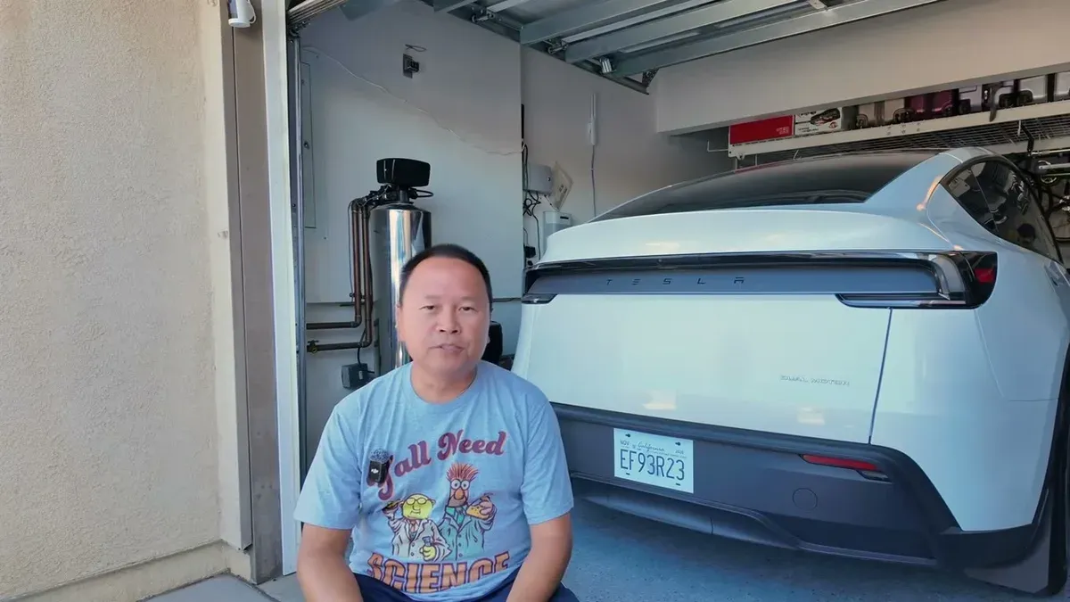 Sherwin sitting in his garage in front of a white Tesla Model Y Juniper, introducing the cost breakdown video