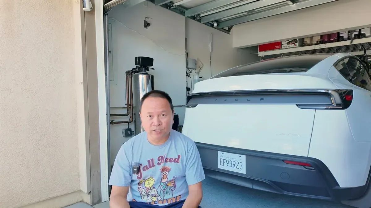 Sherwin in his garage going over the insurance numbers for his three EVs after adding the Model Y Juniper