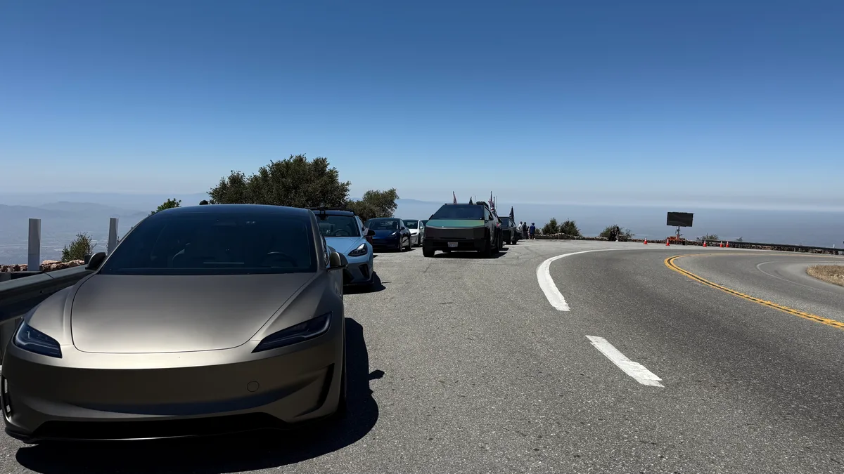 Matte gold Tesla parked at a mountain overlook in SoCal with a scenic view behind it