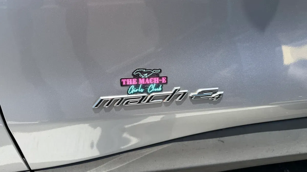 Custom THE MACH-E Girls Club badge above the Mach-E emblem on Keisha's silver Mustang