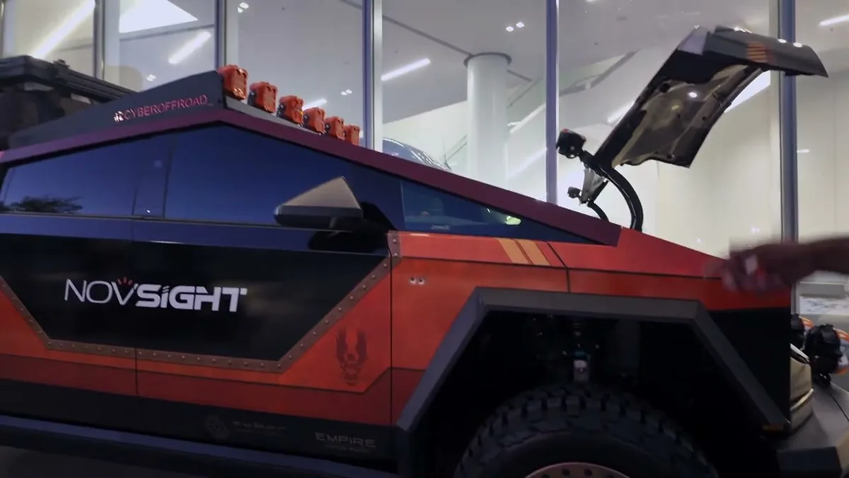 Close-up of Jerry's orange and black Cybertruck with Empire Customs wrap and NovSight branding